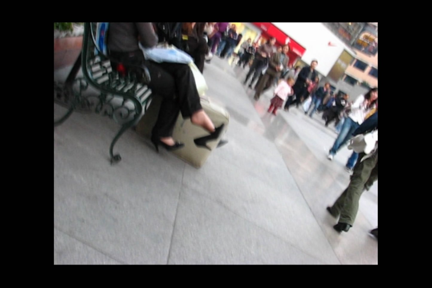 White suitcase and dangling black shoes